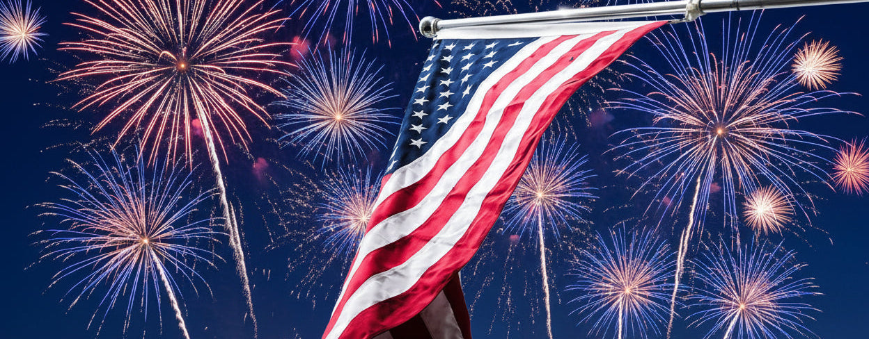 American flag waving against a blue sky with white clouds